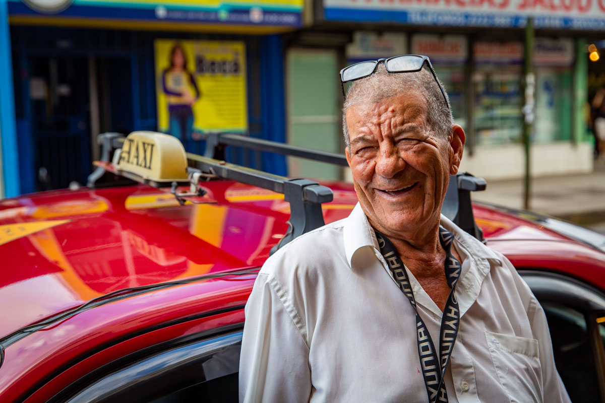 Costa Rica driver smiling standing next to taxi